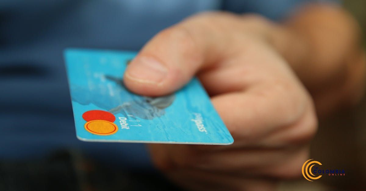 A person is holding a blue credit card in their hand.