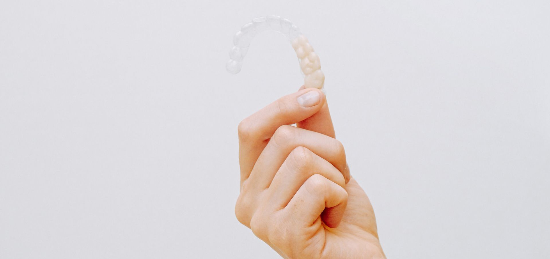 a person is holding a clear brace in their hand .