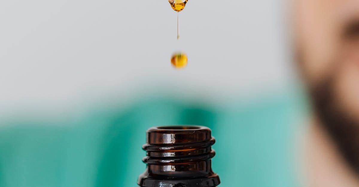 A drop of cbd oil is being poured into a bottle.