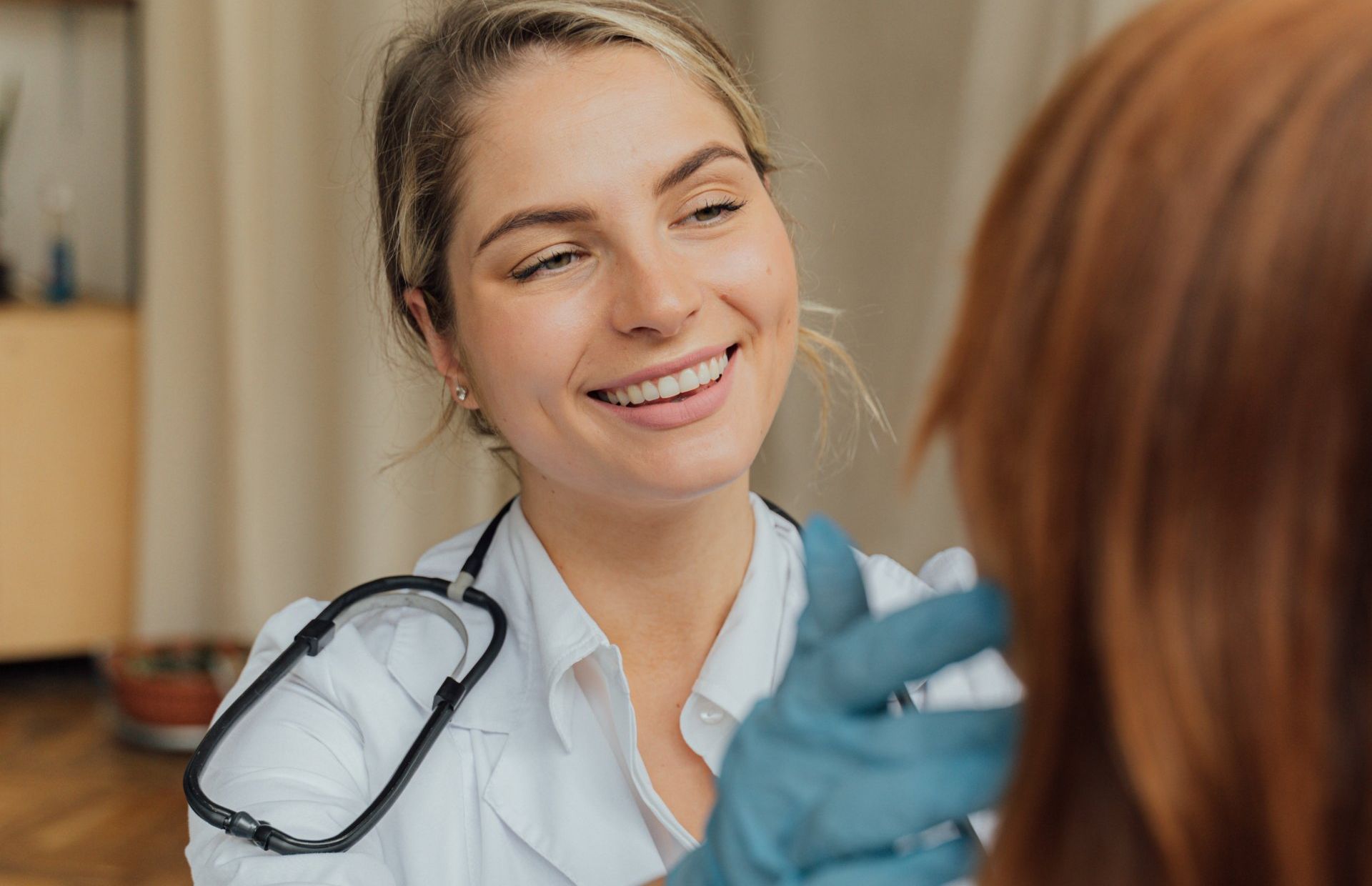 a female doctor is smiling while talking to a patient .