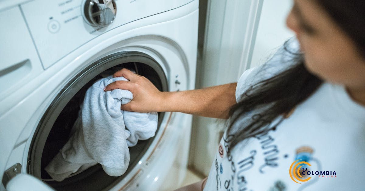 A woman is putting a brazillian butt lift legging in a washing machine.