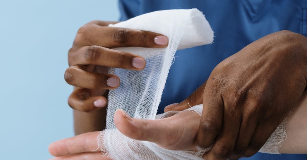 A person is wrapping their hand with a bandage.