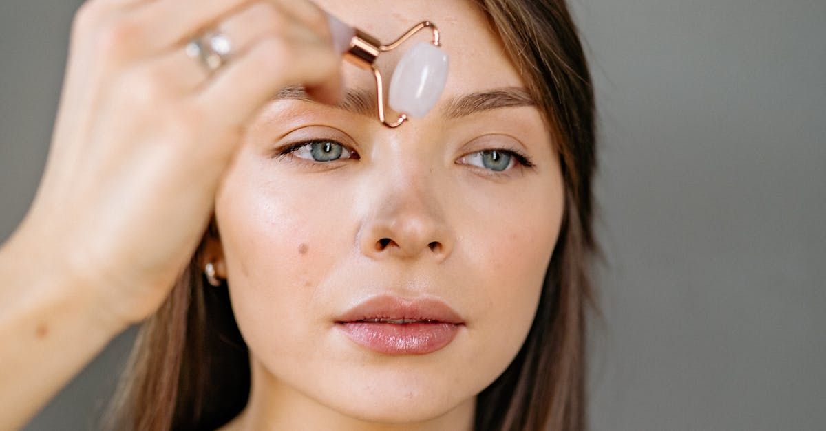 A woman is using an ice roller on her face.