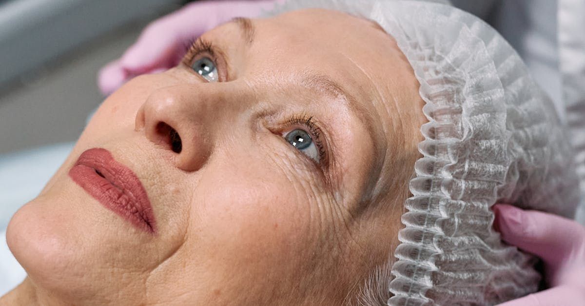 An elderly woman is getting a facial treatment at a beauty salon.