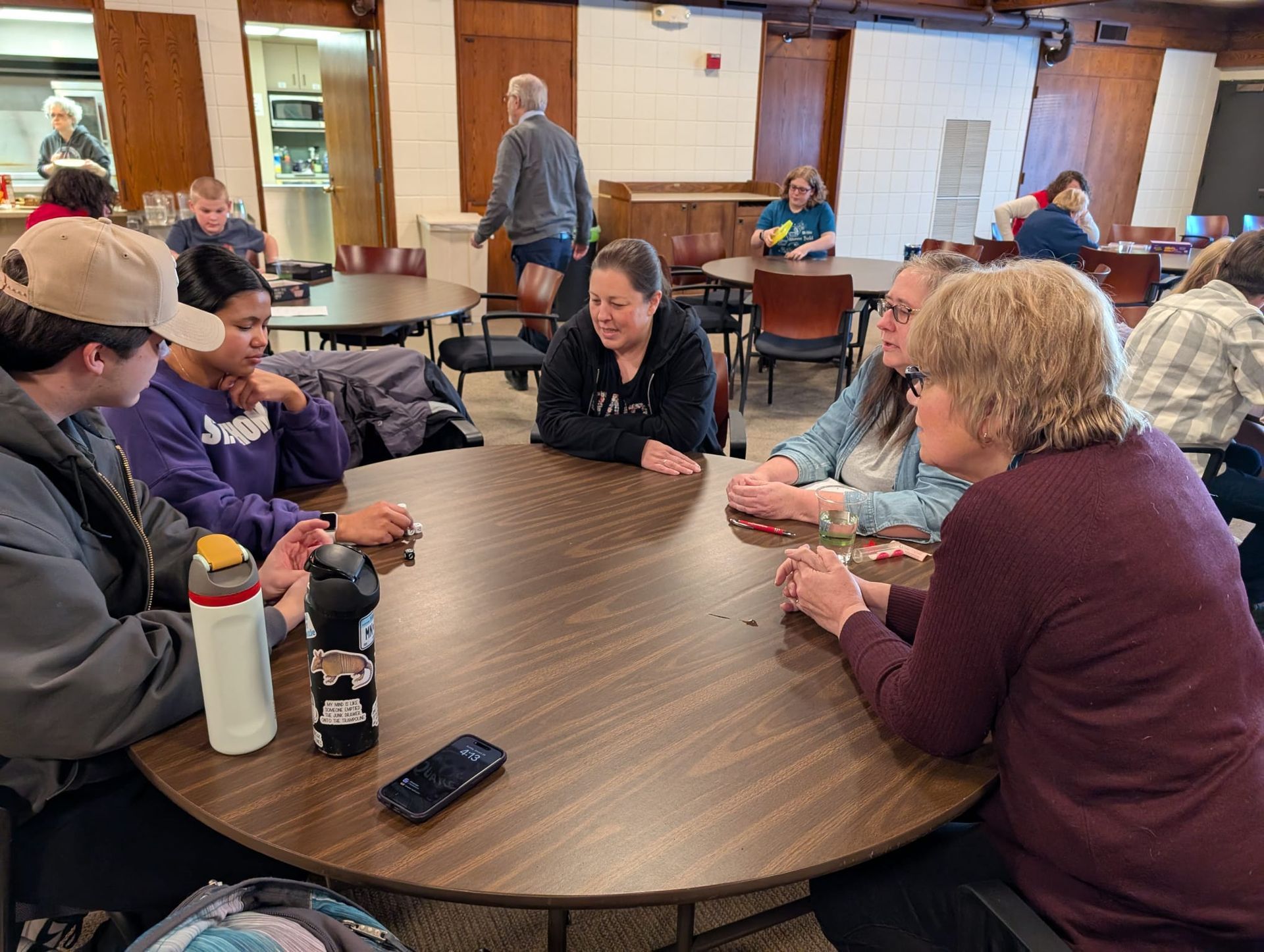 A group of people are sitting around a table in a room.