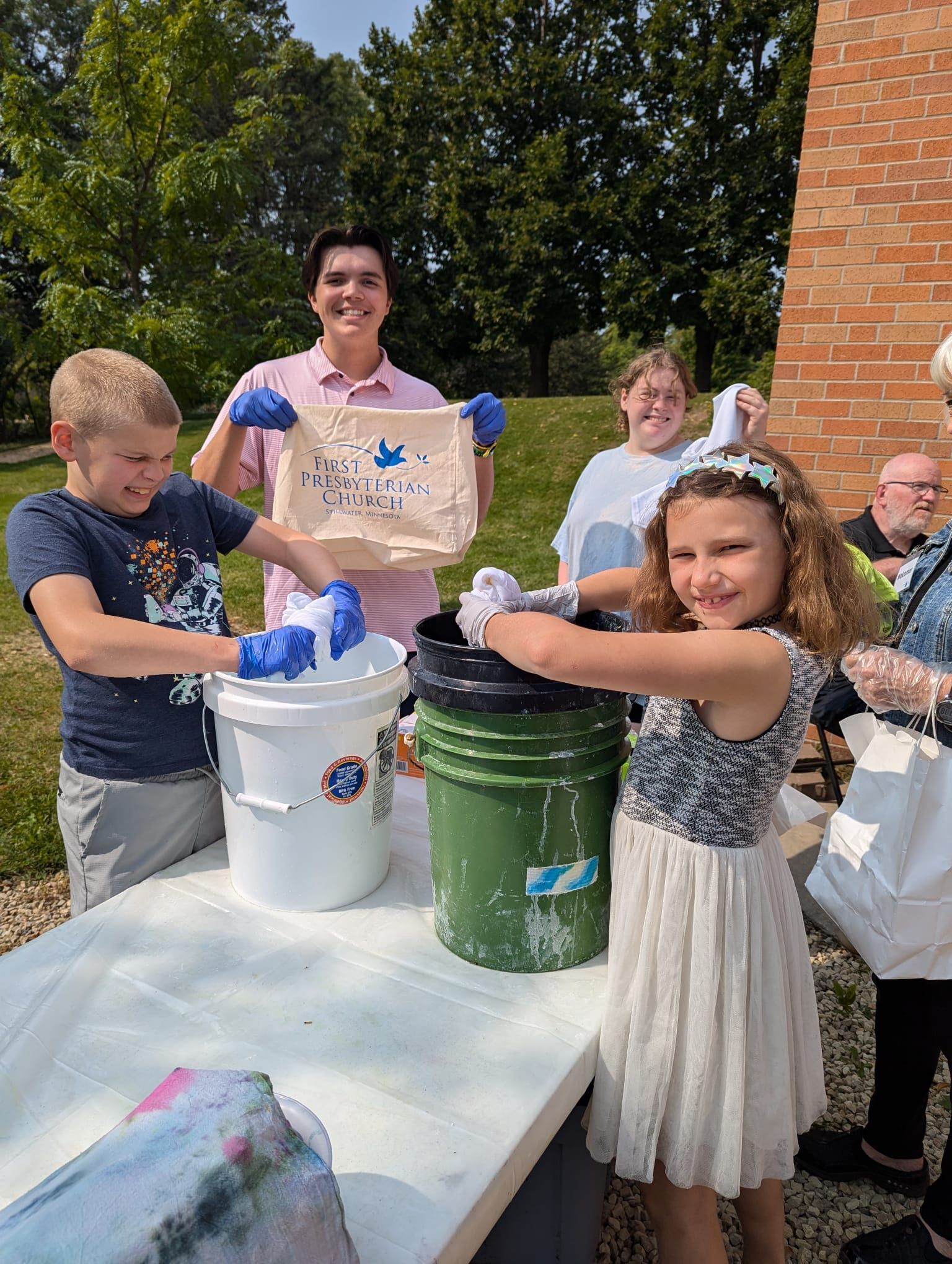 A group of people are standing around a table with buckets of water.