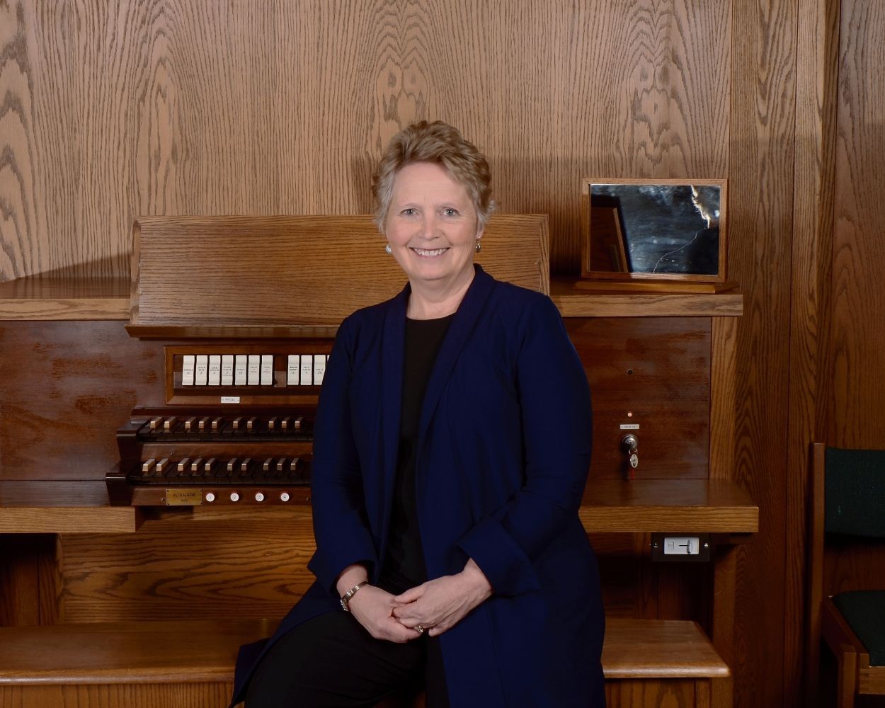 A woman is sitting in front of an organ.
