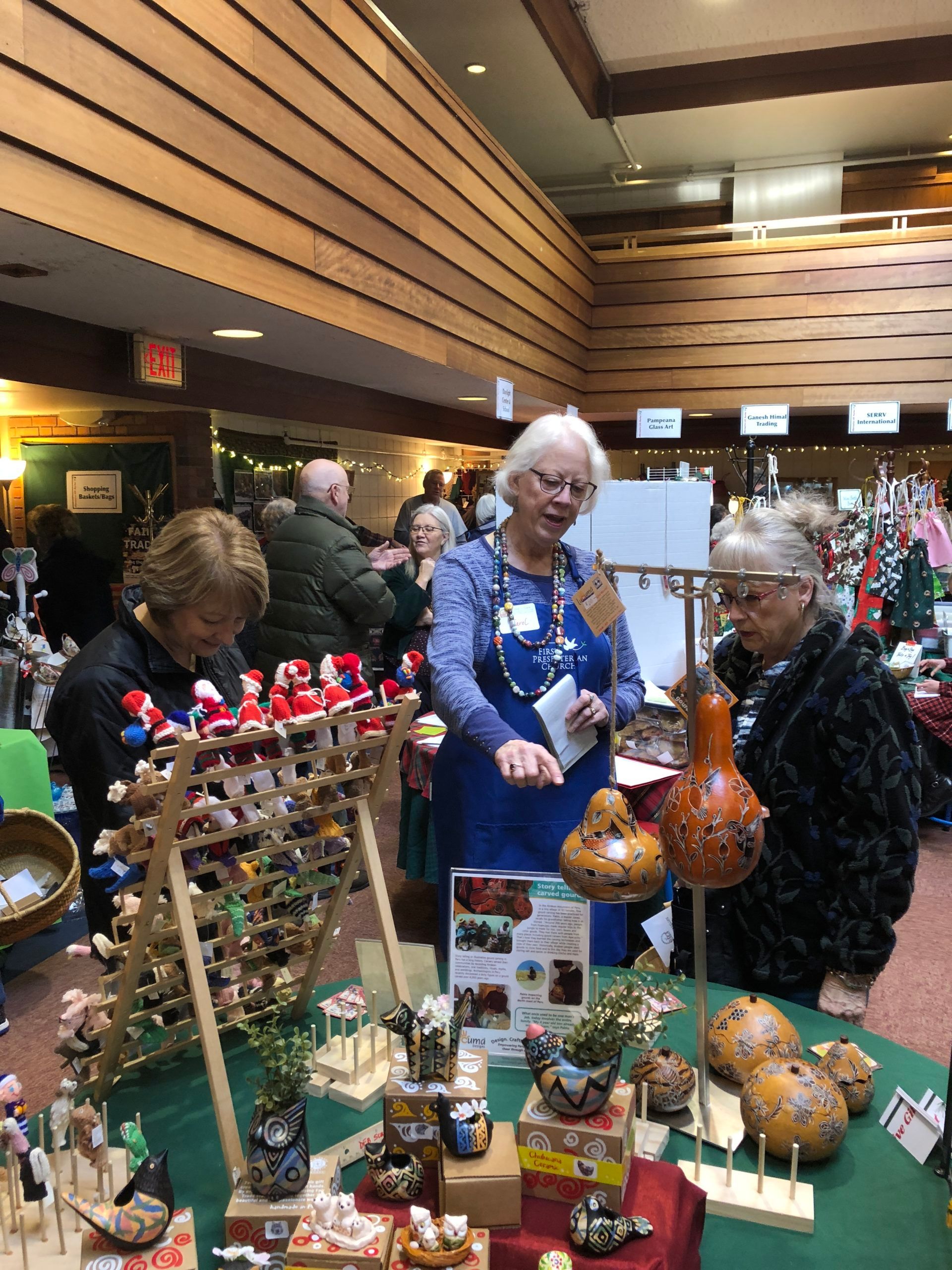 A group of women are standing around a table at a christmas market.