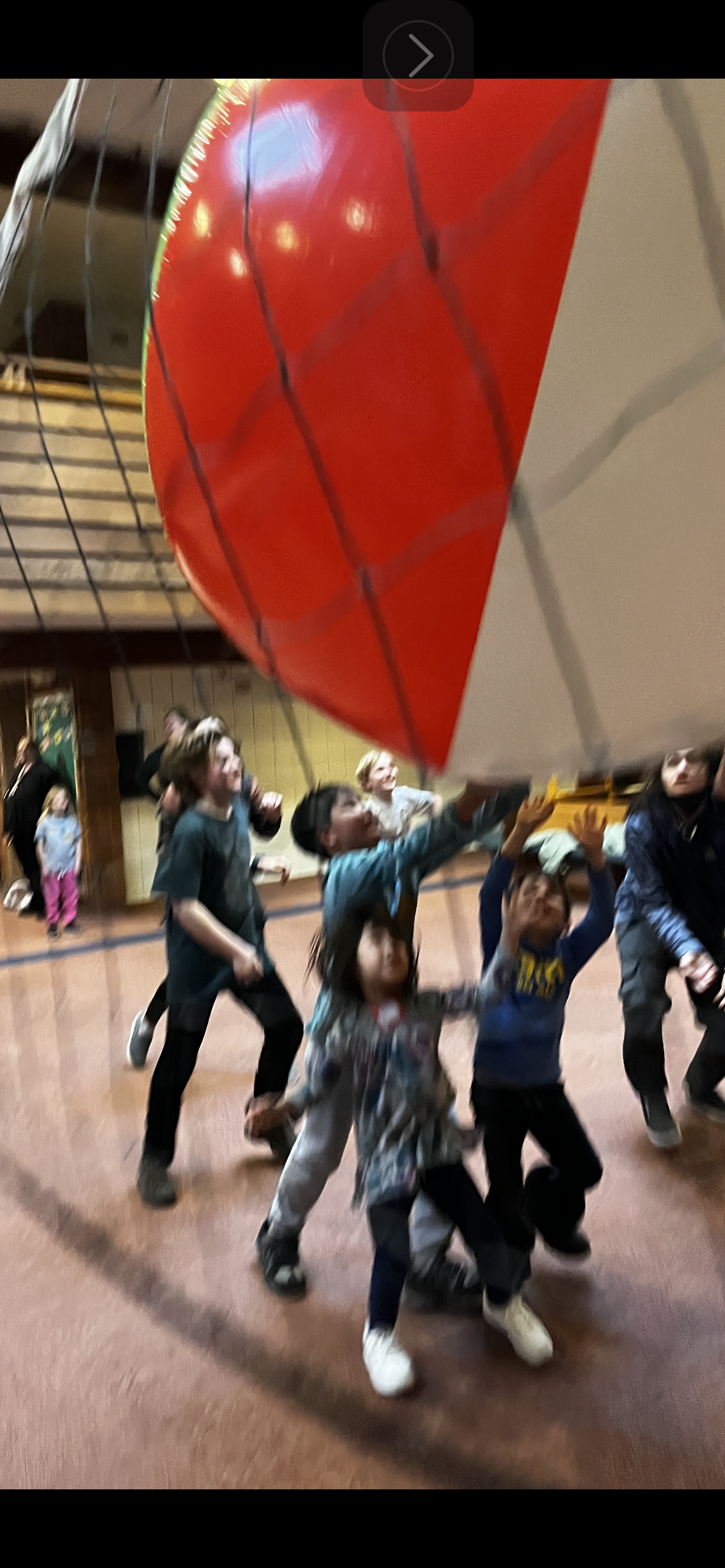 A group of children are playing with a large beach ball
