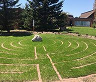 A labyrinth in the middle of a lush green field.