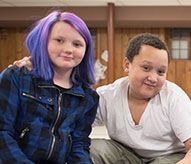 A boy and a girl are sitting next to each other.