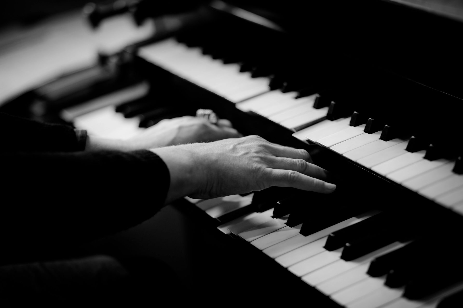 A black and white photo of a person playing a piano