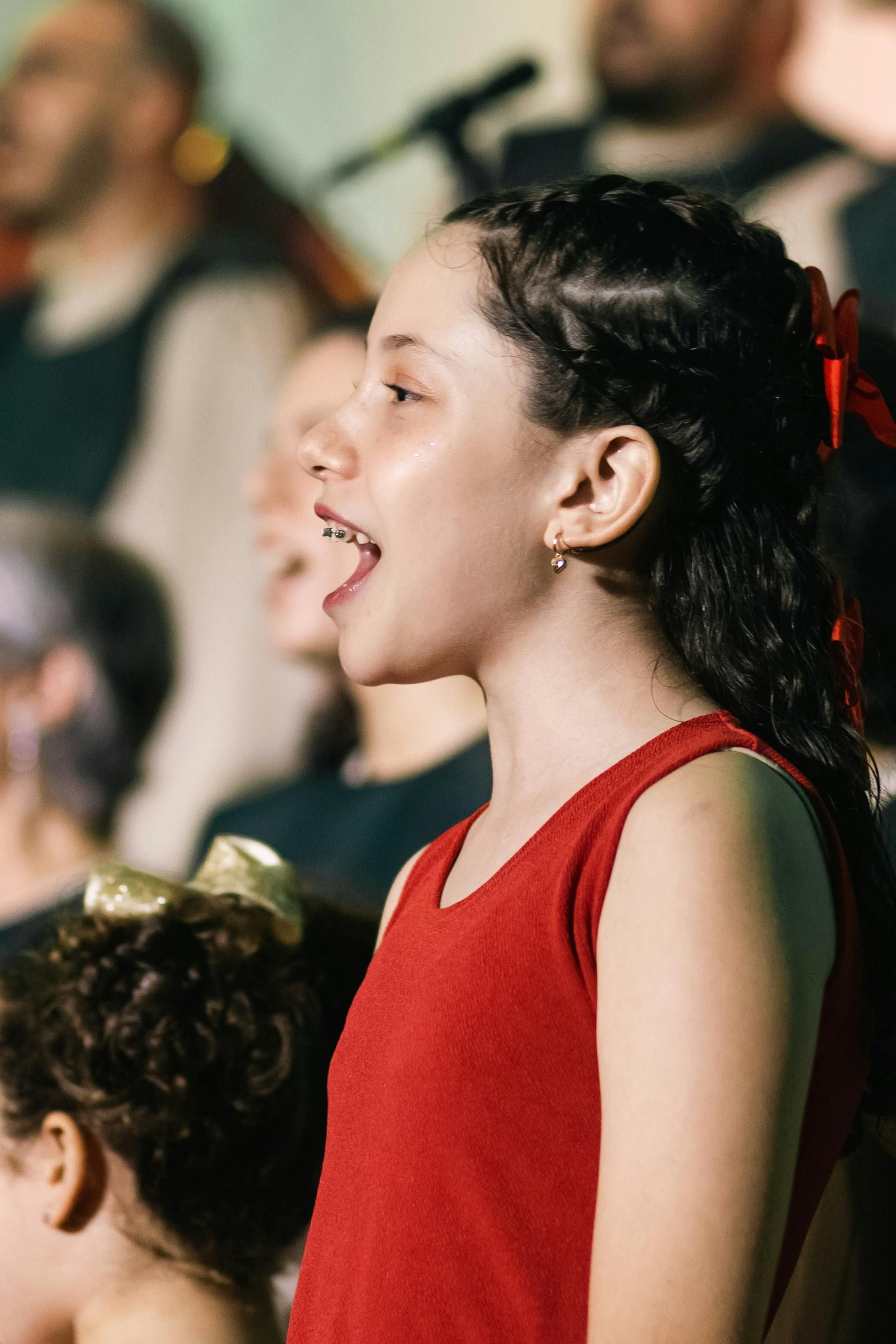 A young girl is singing in a choir.