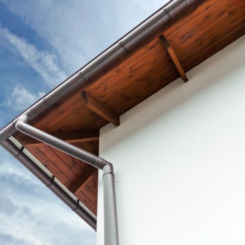 Una casa bianca con tetto e grondaie in legno