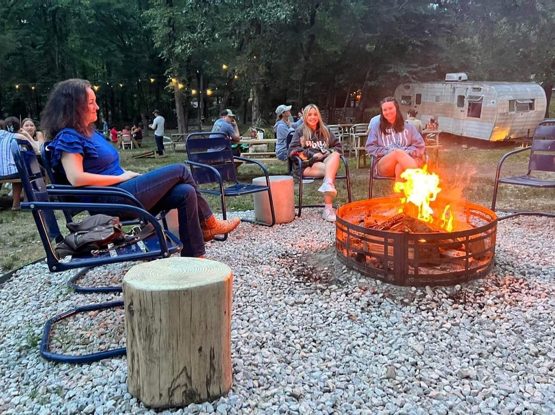 A group of people are sitting around a fire pit.