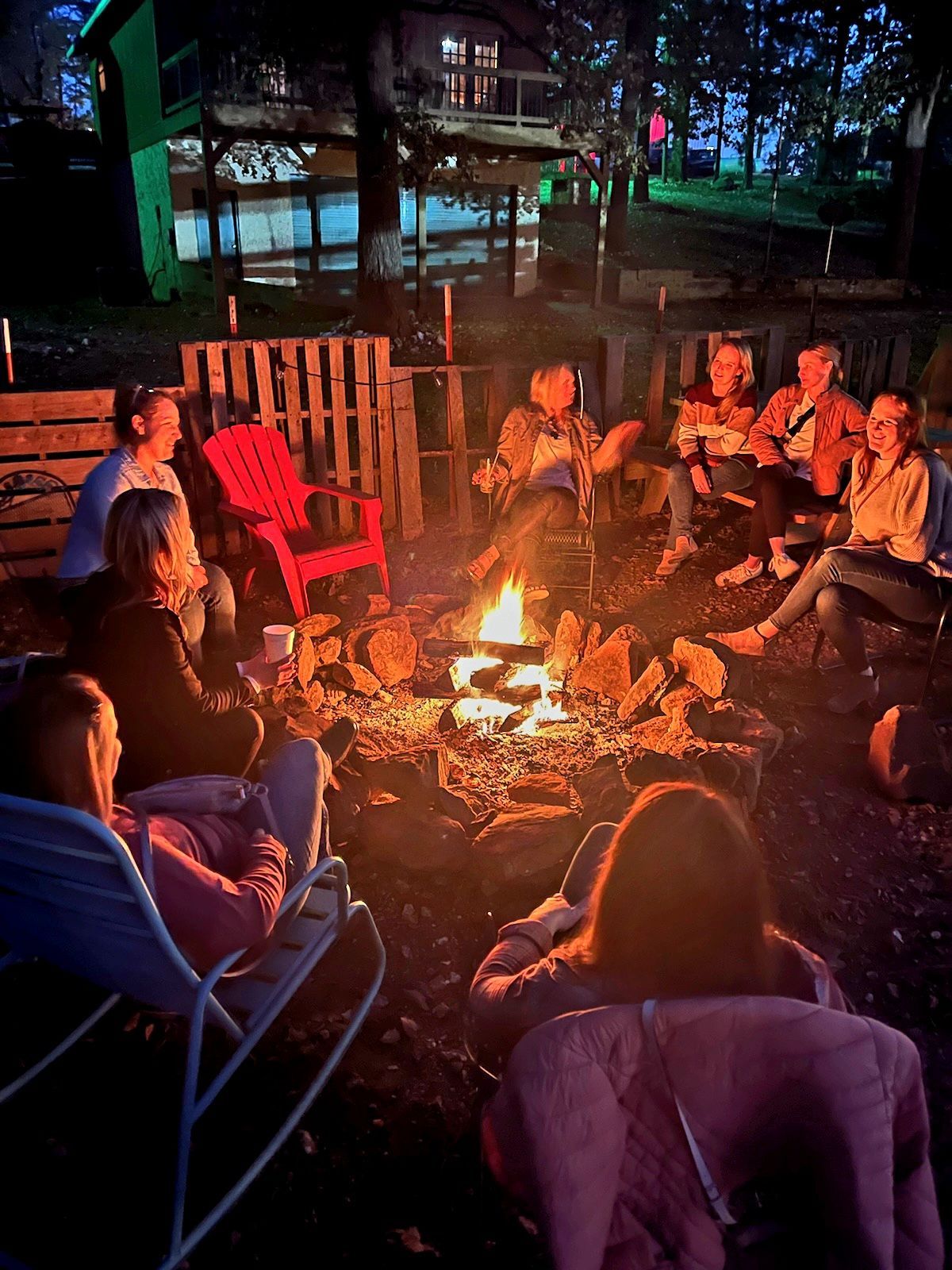 A group of people are sitting around a fire pit.