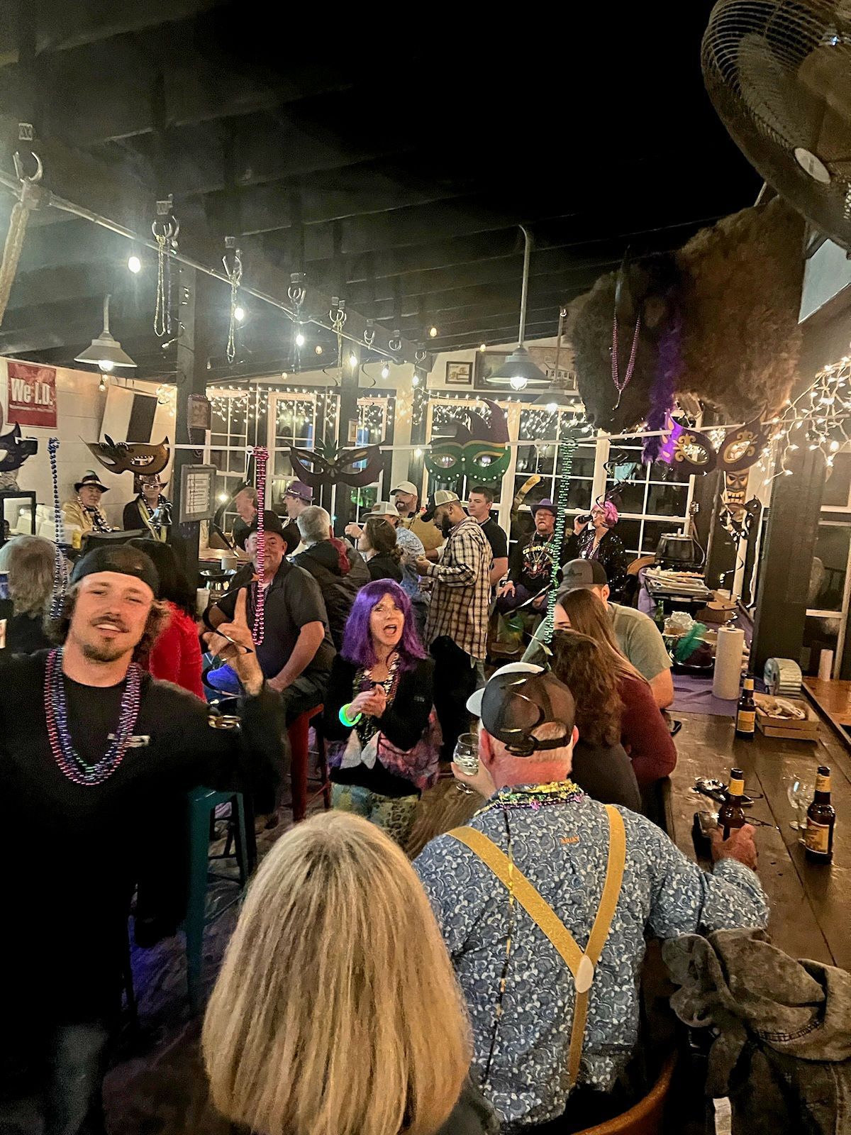 A large group of people are sitting at a bar.