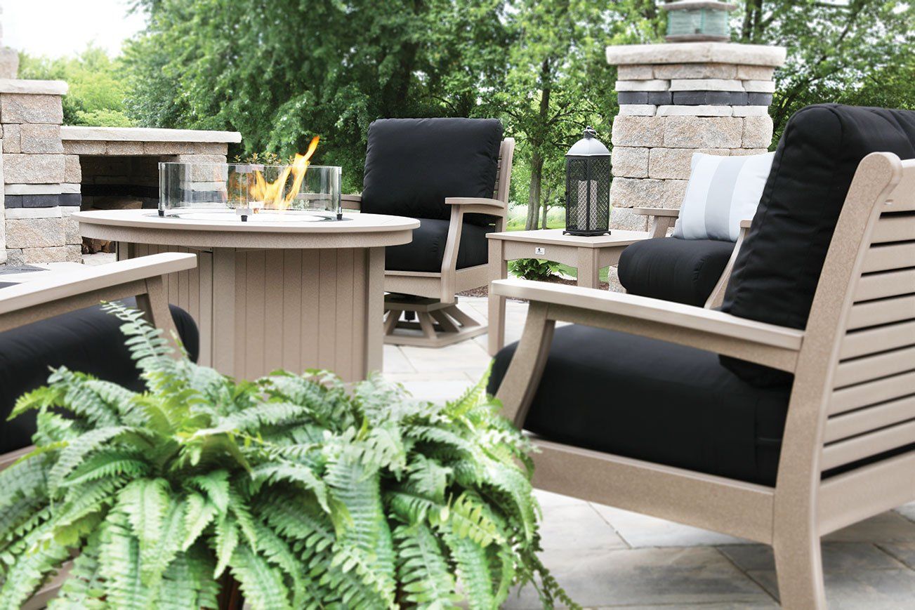 Deep seated outdoor club chairs with thick cushions made from sunbrella fabric and recycled poly lumber near propane fire pit on Ohio paver patio
