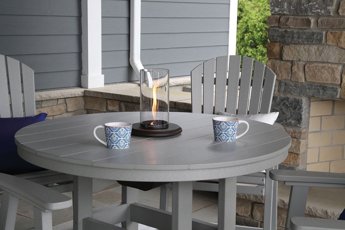 Round amish weather resistant round dining table with fire lantern for morning coffee outside on Ohio enclosed porch.