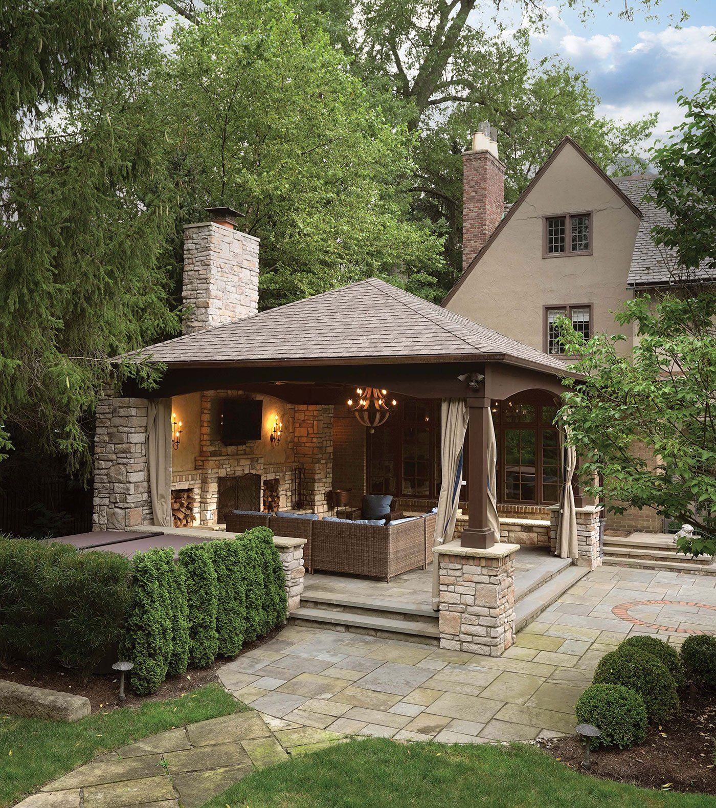 Patio with custom amish pavilion with fireplace and stone posts