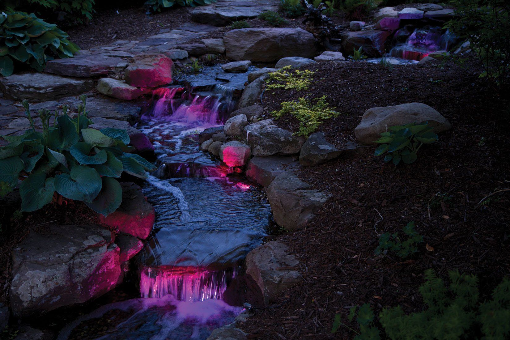 Pondless backyard Ohio waterfall at night with color changing lights