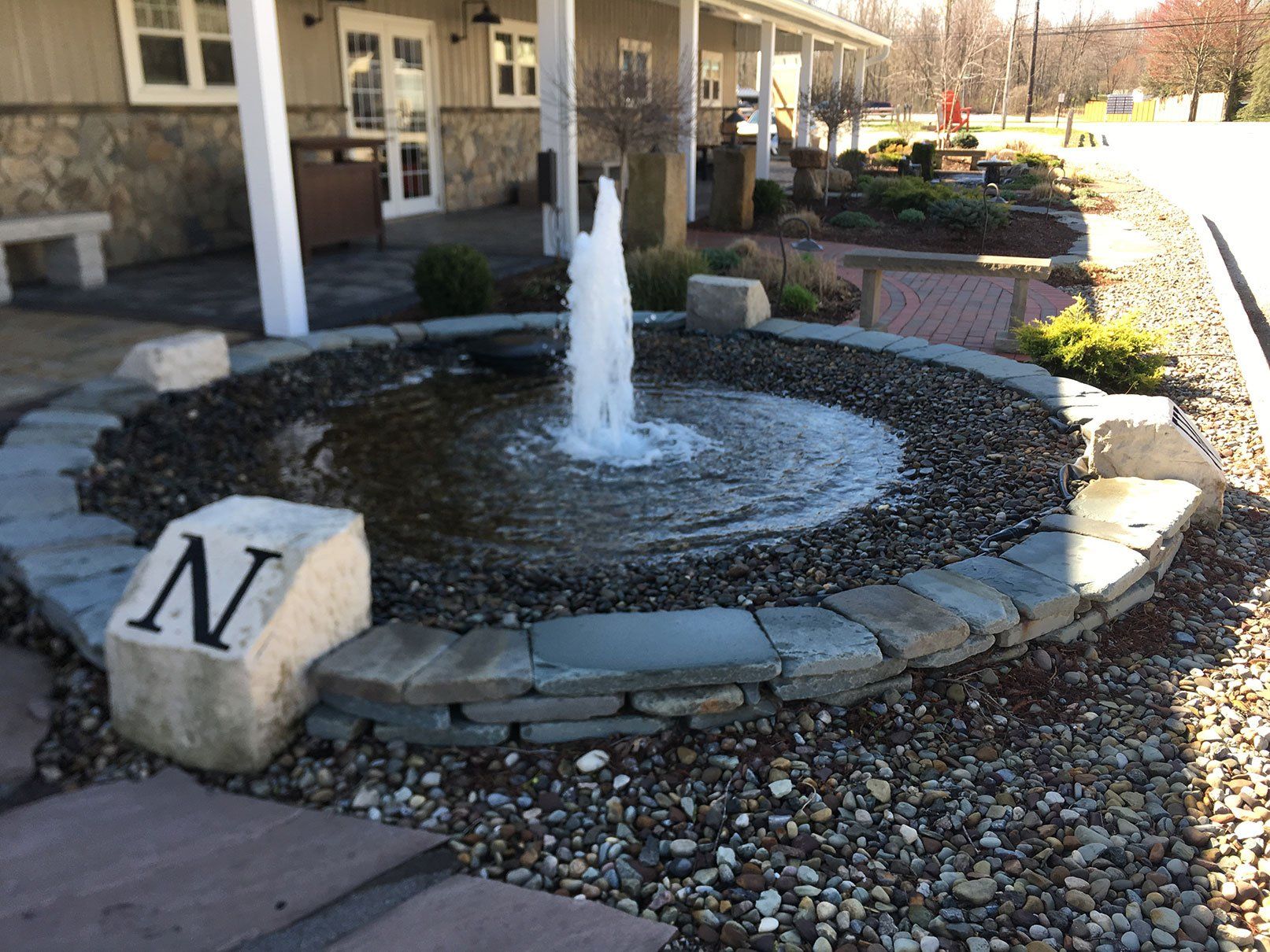 Engraved direction boulders surrounding a geiser fountain water feature