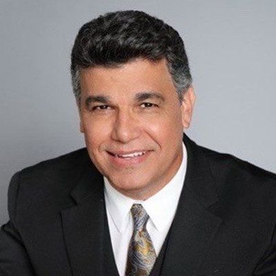 A man in a suit and tie is smiling for the camera.