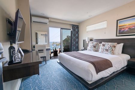 A hotel room with a large bed and a view of the ocean
