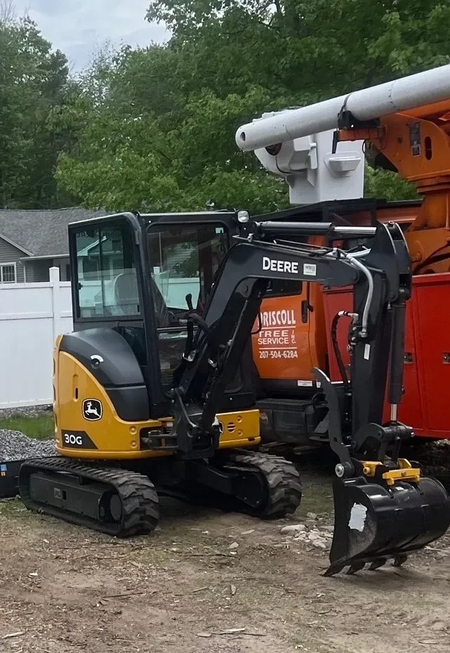 Yellow and black John Deere 30G mini excavator parked outdoors.