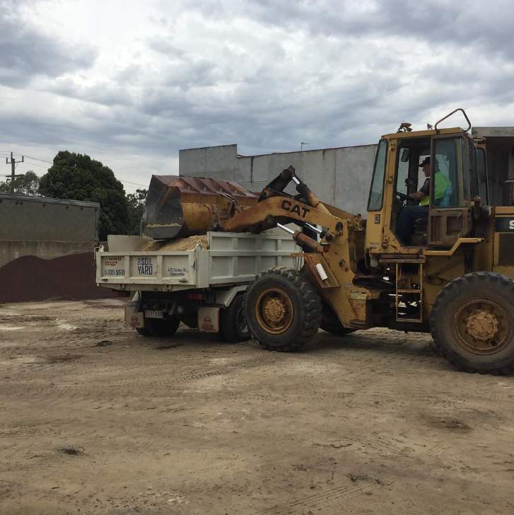 Bulldozer Filling Up Delivery Truck — Landscaping Supplies in Delacombe, VIC