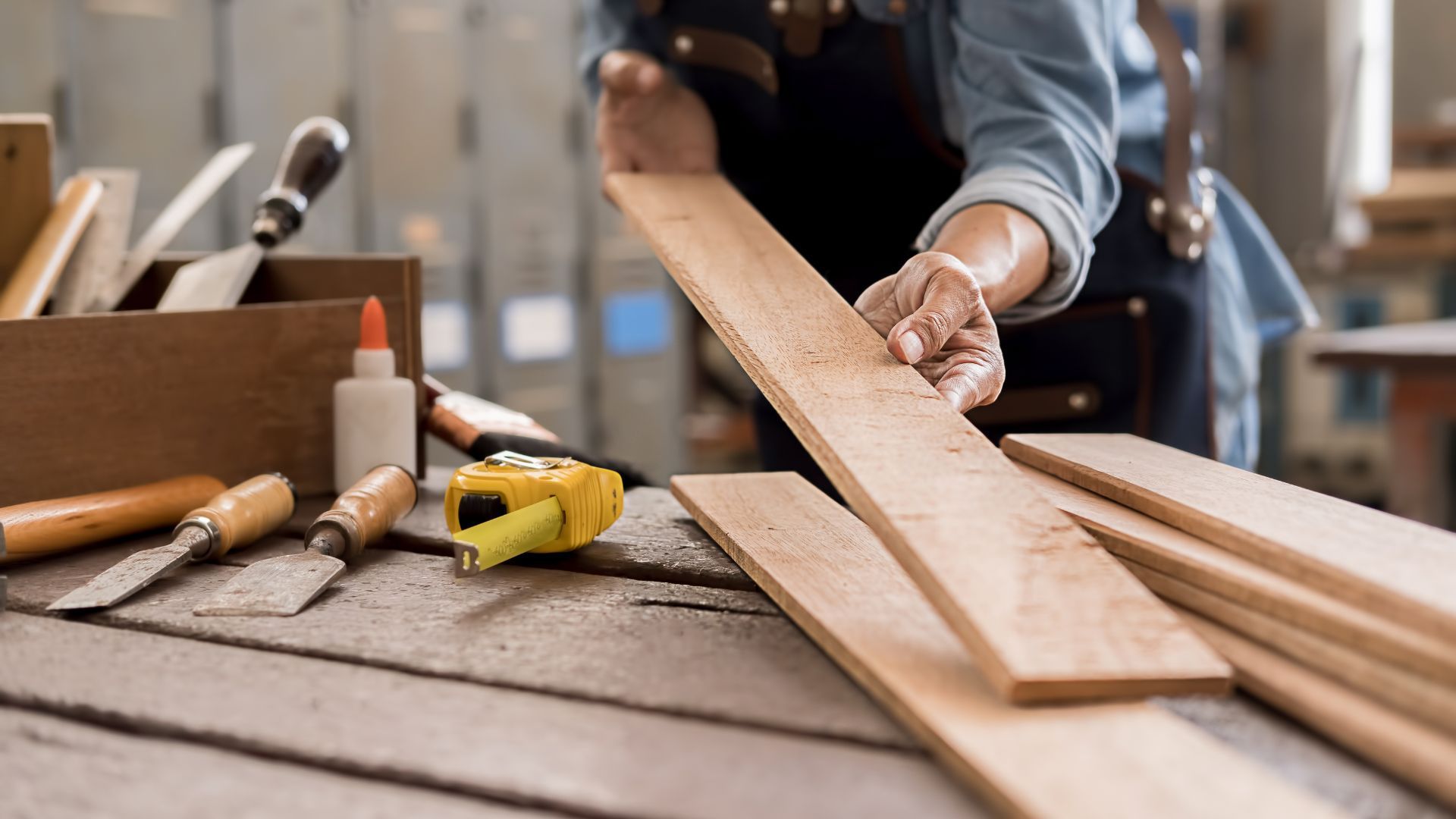 A person is cutting a piece of wood on a table.
