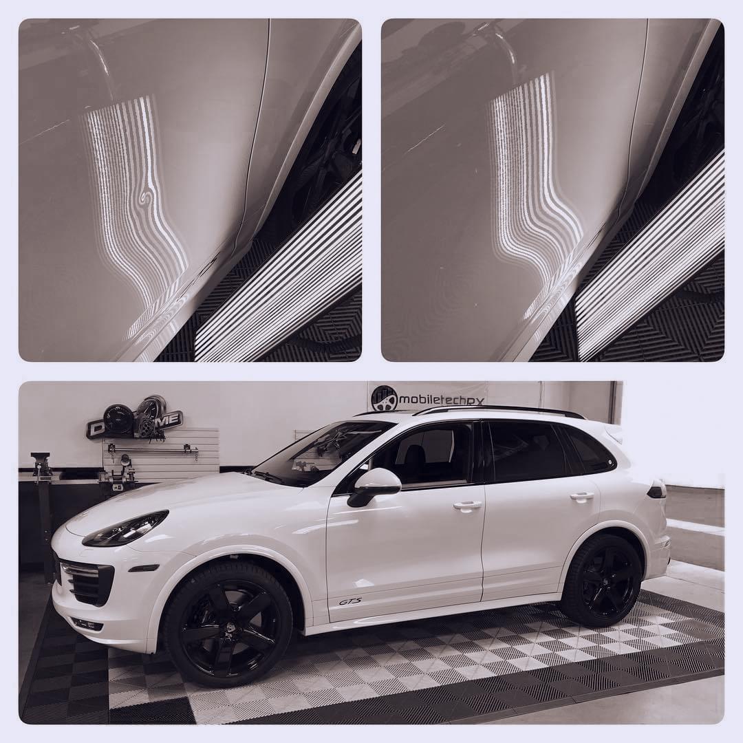 A white porsche cayenne is parked in a garage for paintless dent repair