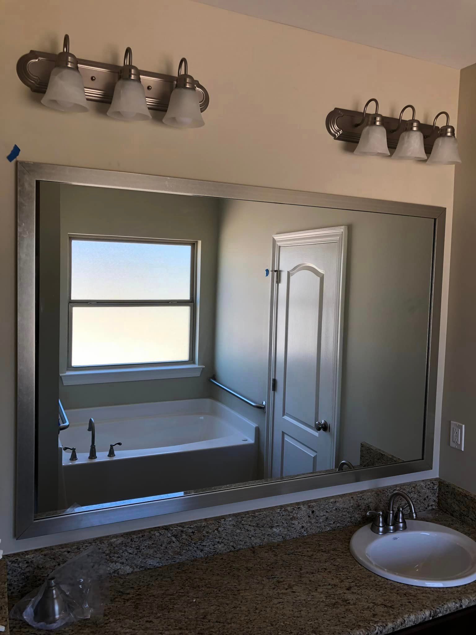 A bathroom with a large mirror and a bathtub