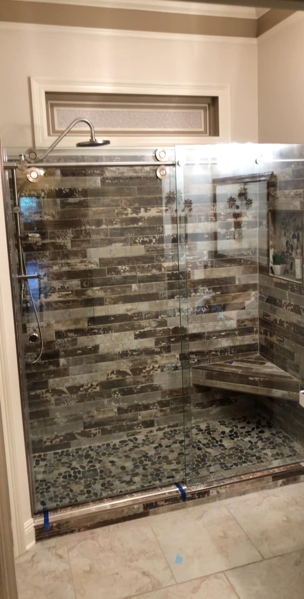 A bathroom with a walk in shower with a sliding glass door.