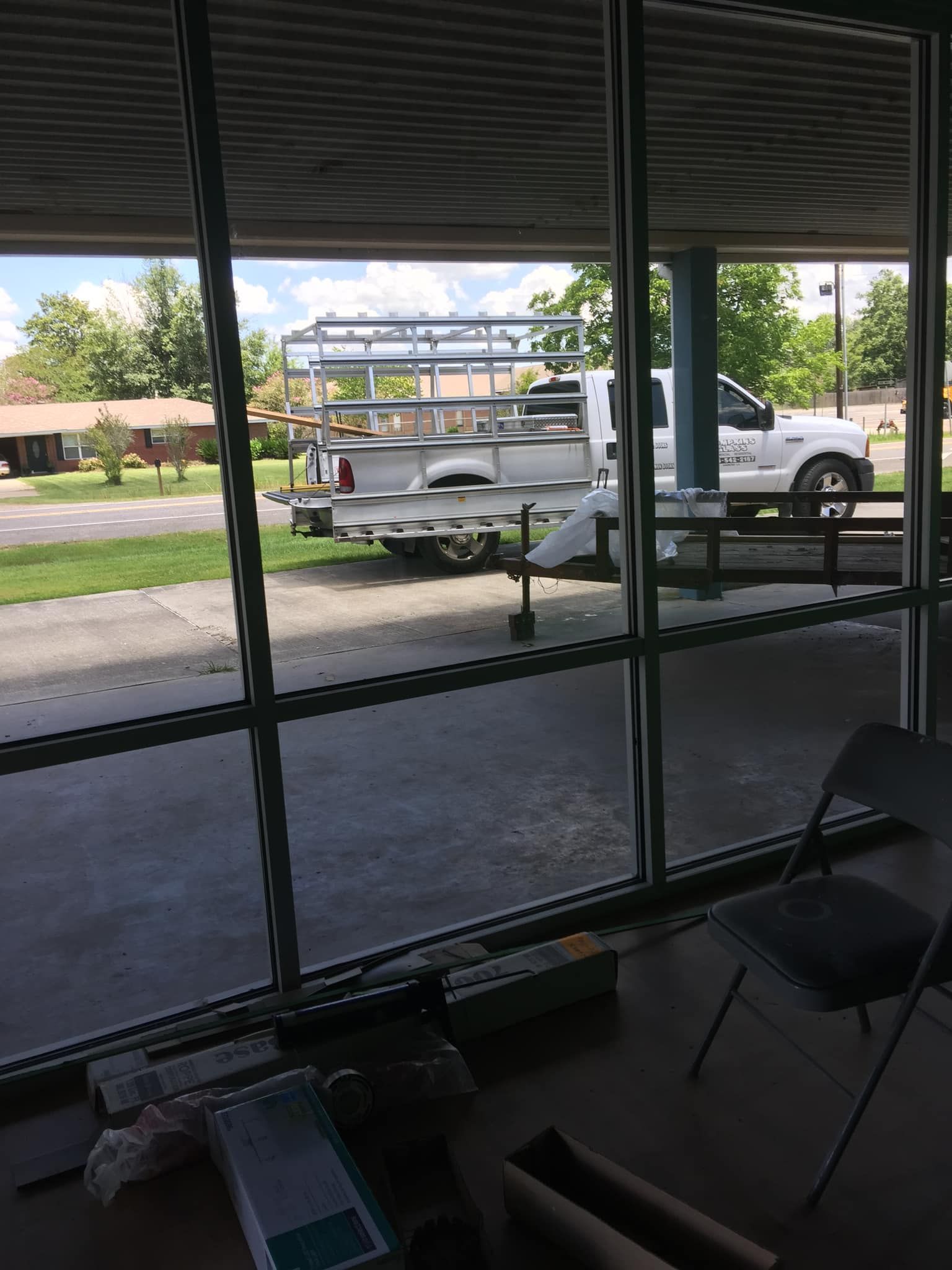 A white truck is parked in front of a window.