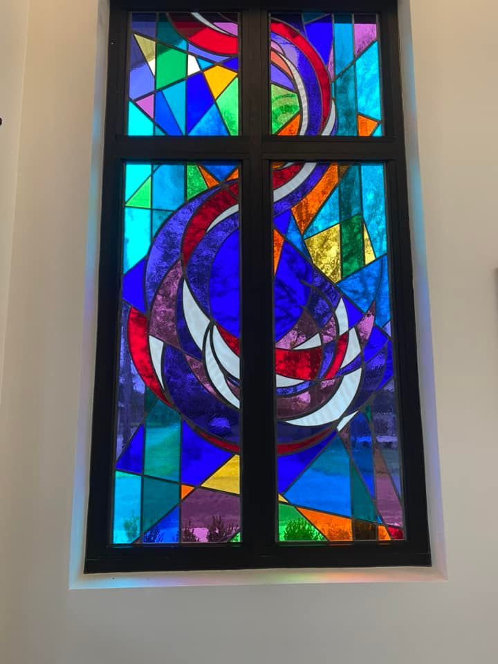 A stained glass window with a cross on it