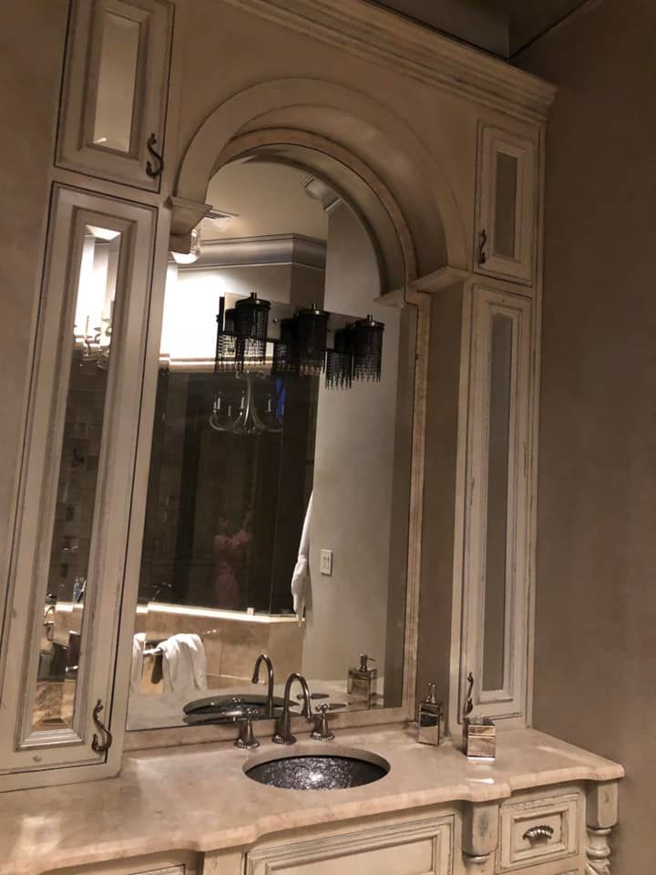 A bathroom with a sink , mirror and cabinets