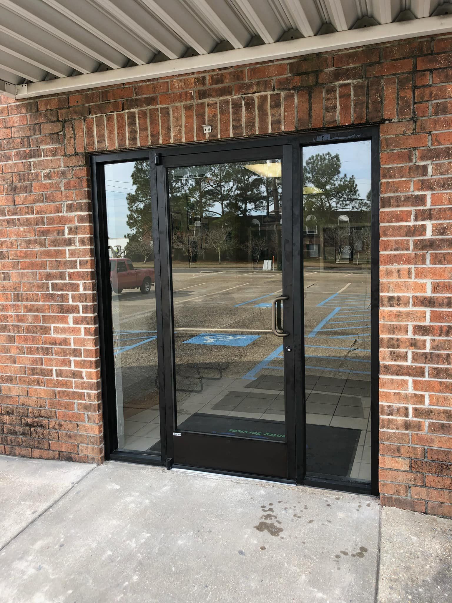 A brick building with a black door and a handicapped parking spot