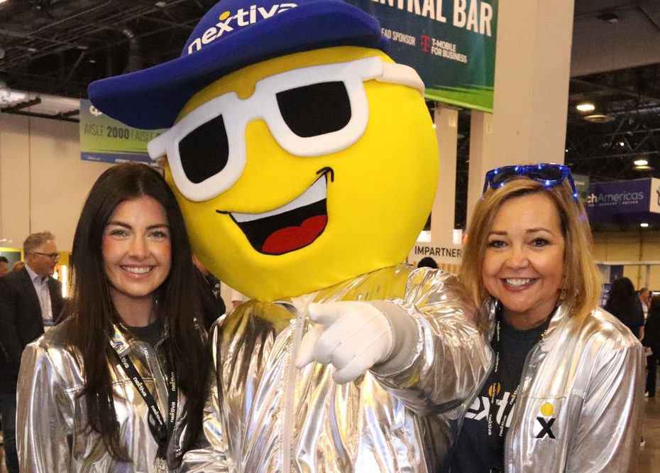 Asian man smiles, holding a tablet, lit by blue and pink light near a window.
