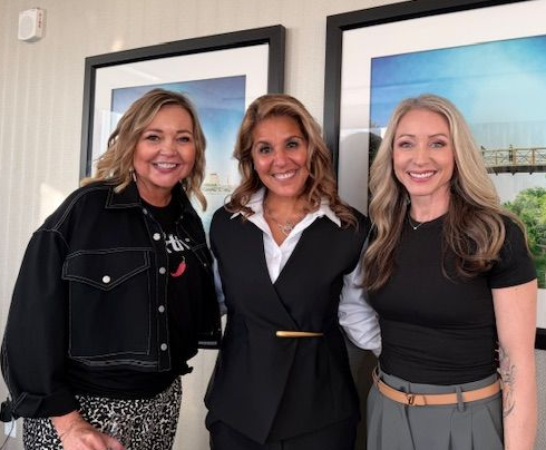 Man clenching fist, celebrating with open mouth, holding laptop. Pink and blue neon lighting on blue background.