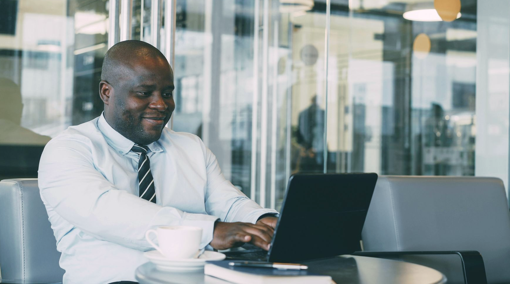 Man in a suit, holding a tablet and pen, looking thoughtful under red and blue lights.
