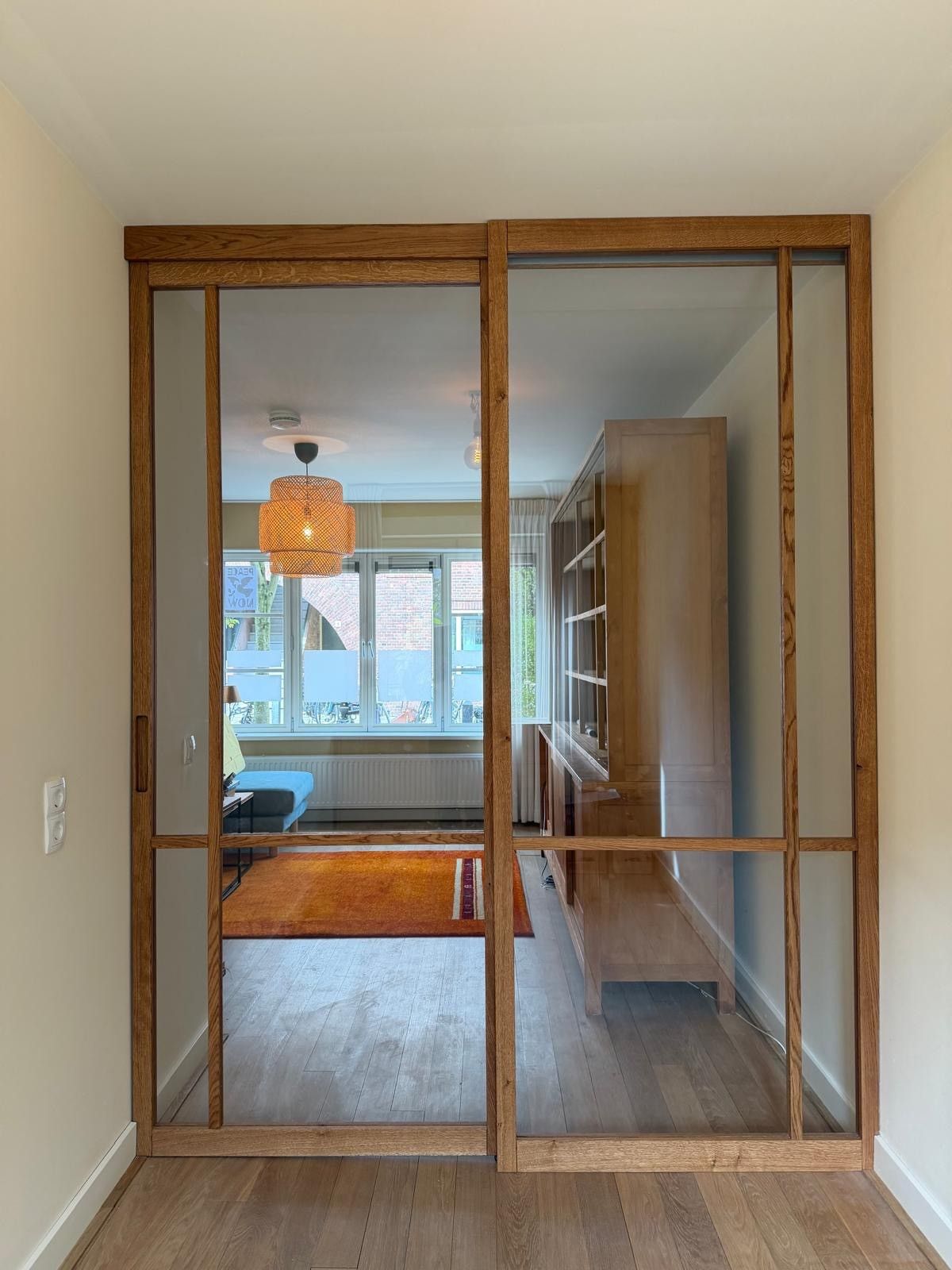 Eiken schuifdeur met vast paneel. Uitgevoerd met helder glas en een soft-close systeem voor geruisloze sluiting.