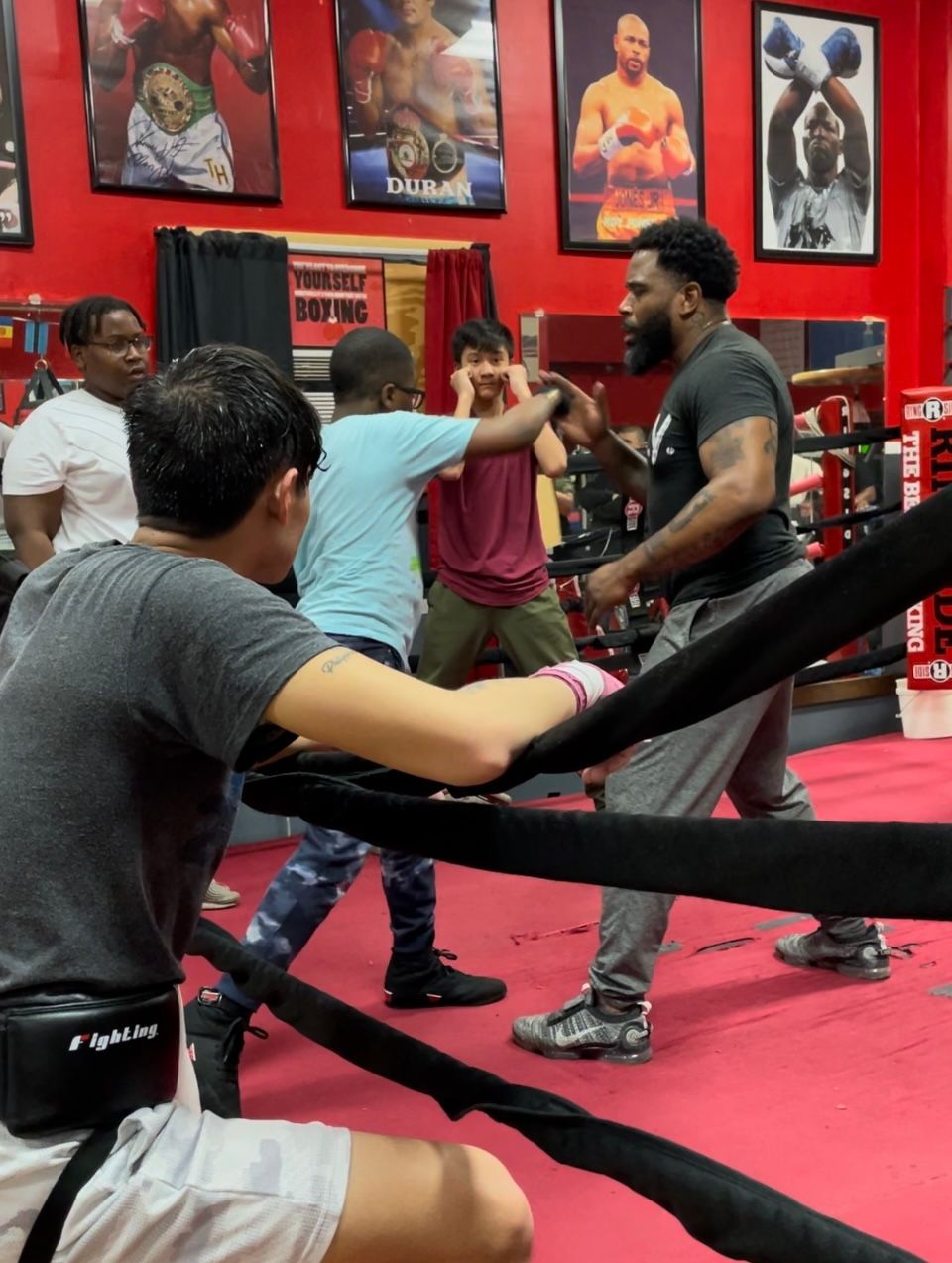 A group of men are boxing in a gym