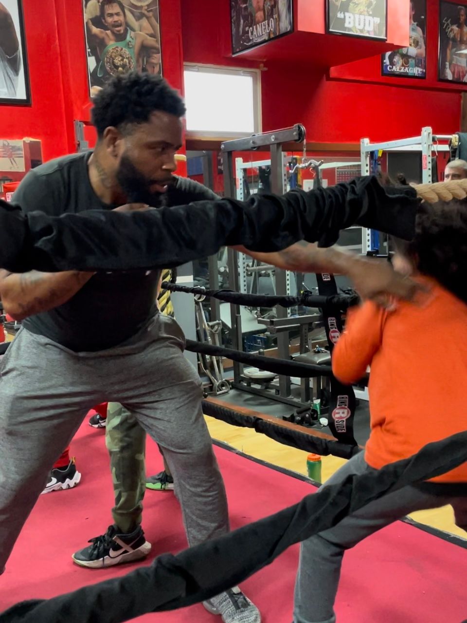 A man and a child are boxing in a gym
