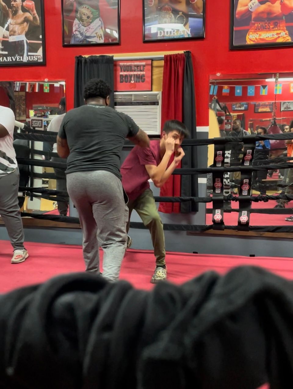 A man is standing in a boxing ring with other people