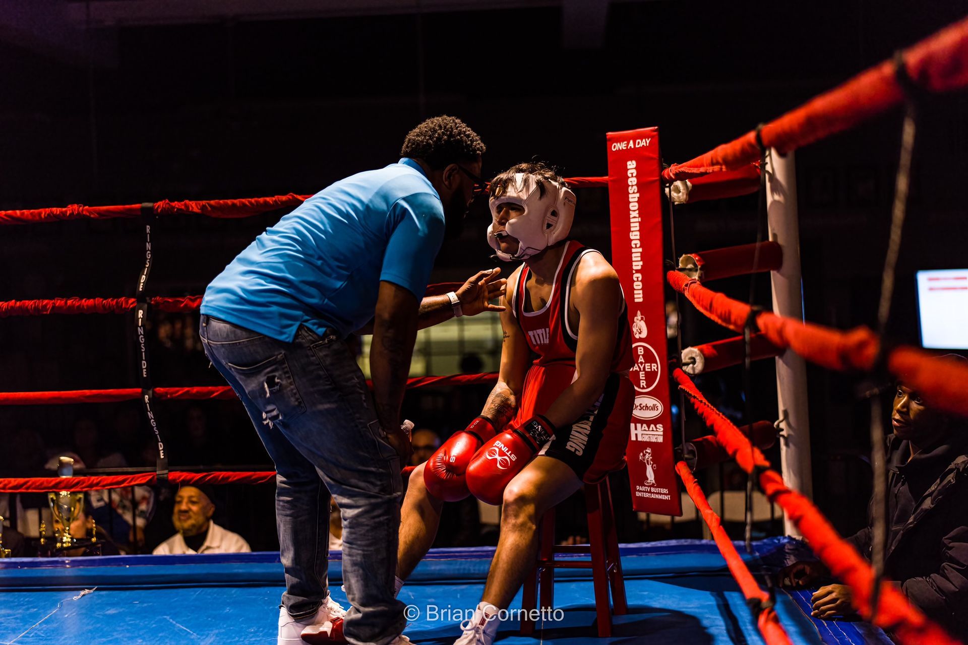 A man is talking to a boxer in a boxing ring