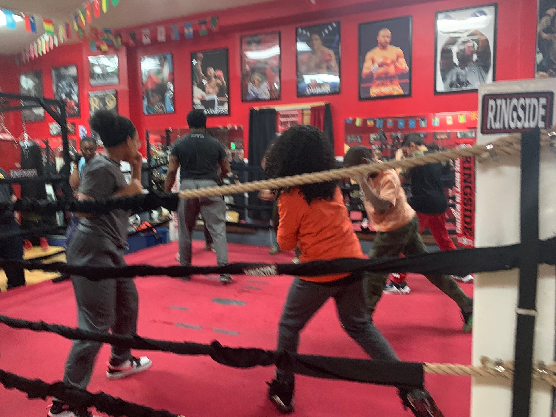 A group of people are boxing in a ring with a sign that says ringside