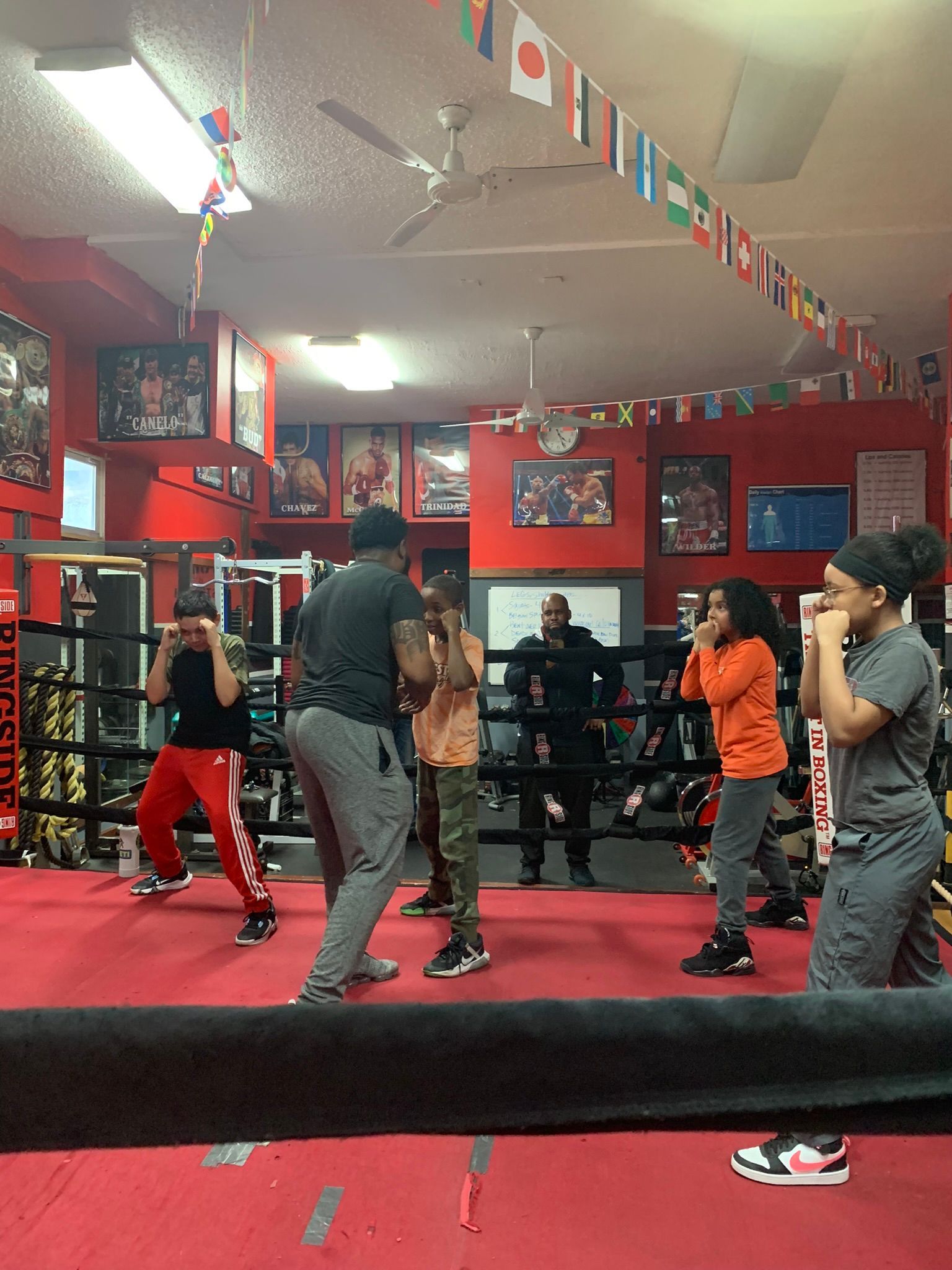 A group of people are practicing boxing in a gym.