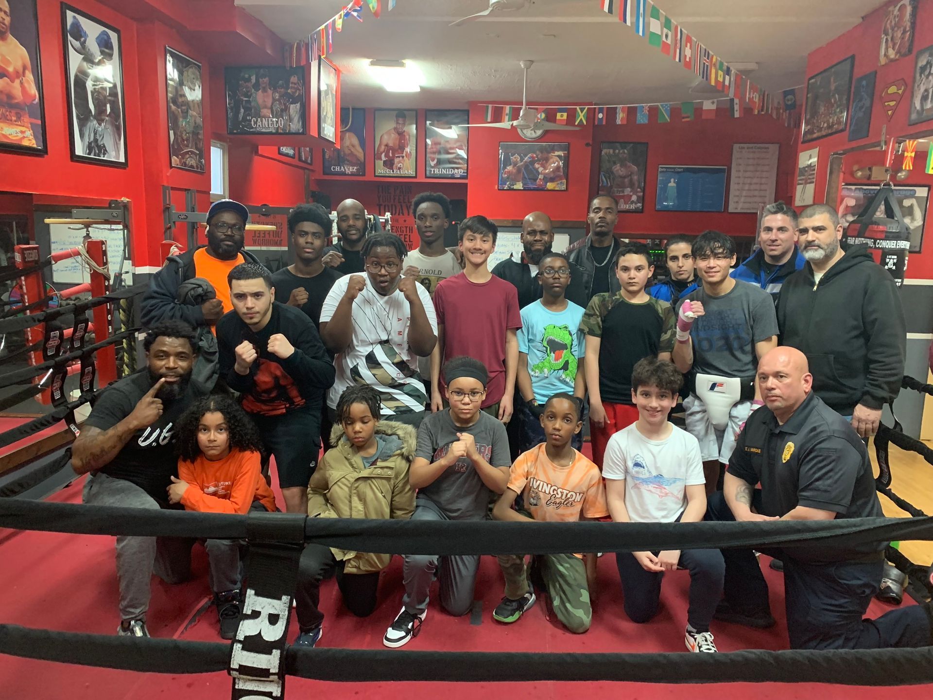 A group of people are posing for a picture in a boxing ring.