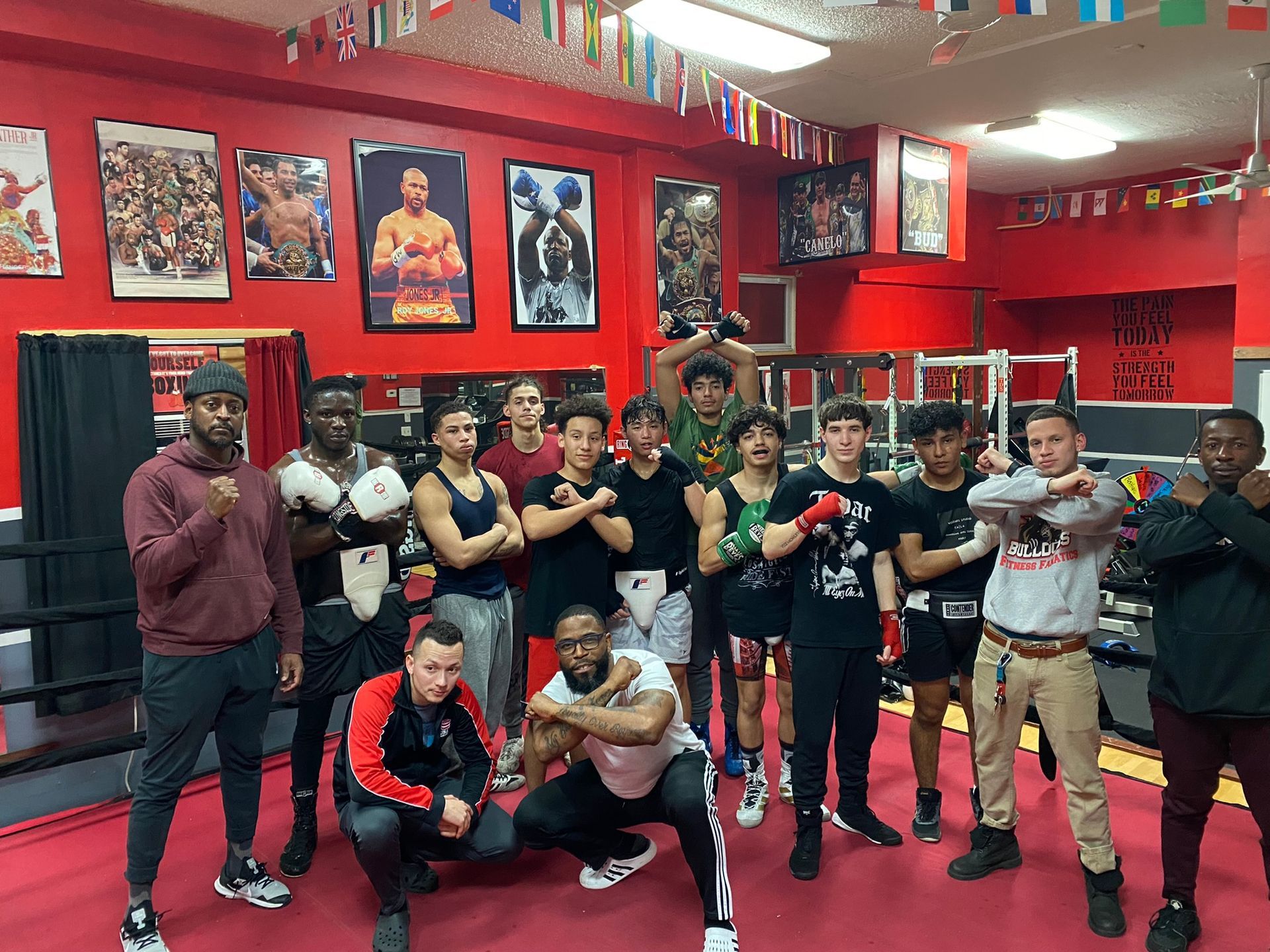 A group of young men are posing for a picture in a boxing gym.